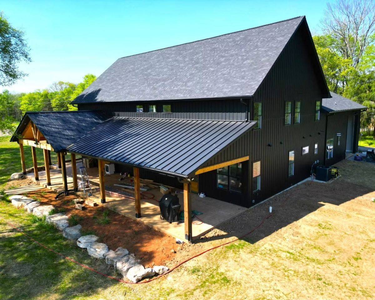 Black barndominium with metal roof and covered porch built in North Idaho